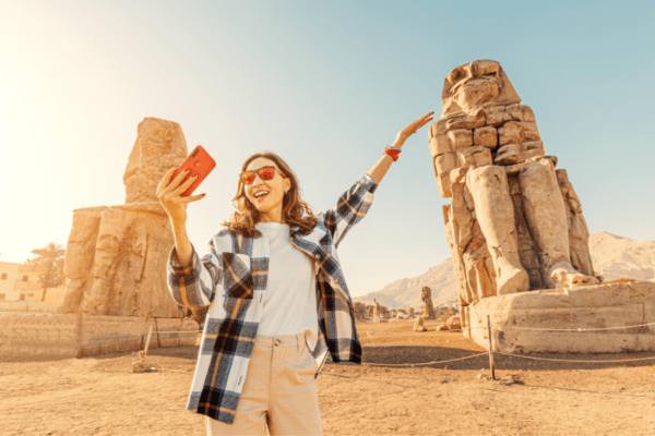Viajera sonriente junto a los Colosos de Memnón en Luxor