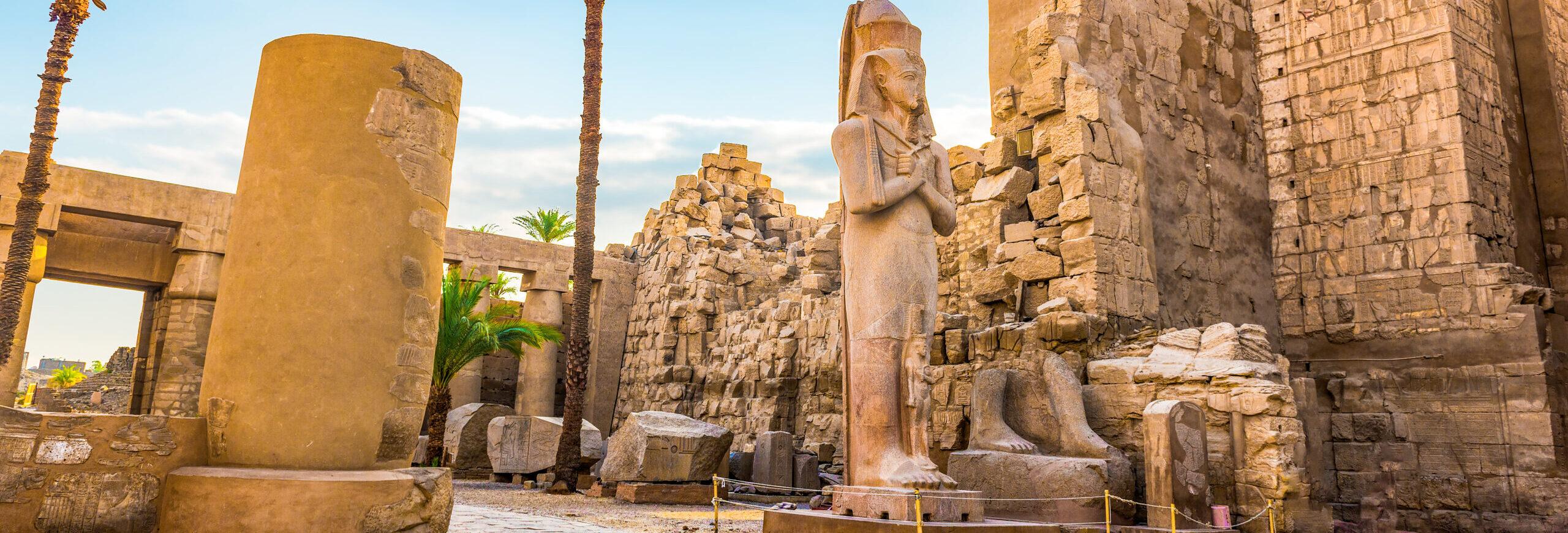 Walking through the columns and statues of Karnak Temple in Luxor during 6 Days Cairo, Luxor, Aswan, and Abu Simbel Tour