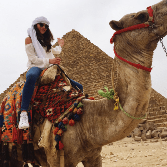 Tourist riding camel near Giza Pyramids - camel ride at giza pyramids