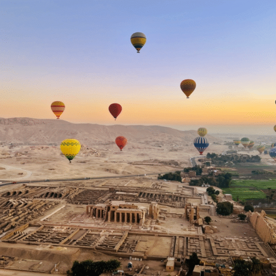 Luxor hot air balloon flying over green fields at sunrise - Hot Air Balloon Ride in Luxor