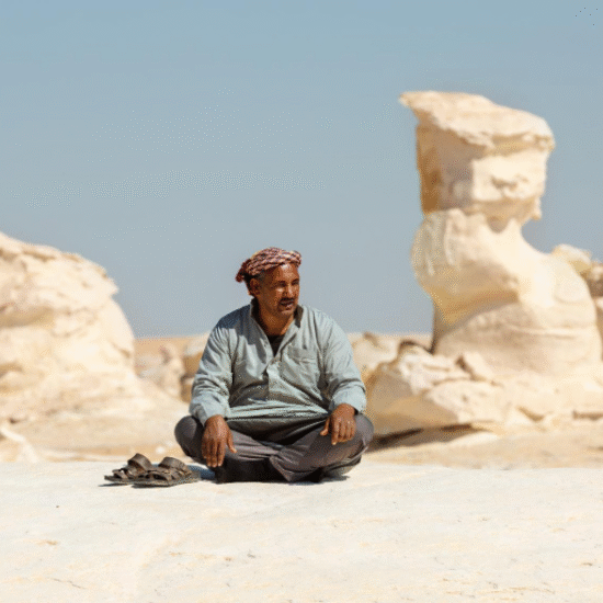 Bedouin man sitting among rock formations in Egypt’s White Desert