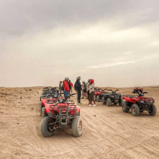 Desert safari in Hurghada with tourists riding camels and enjoying the sunset.