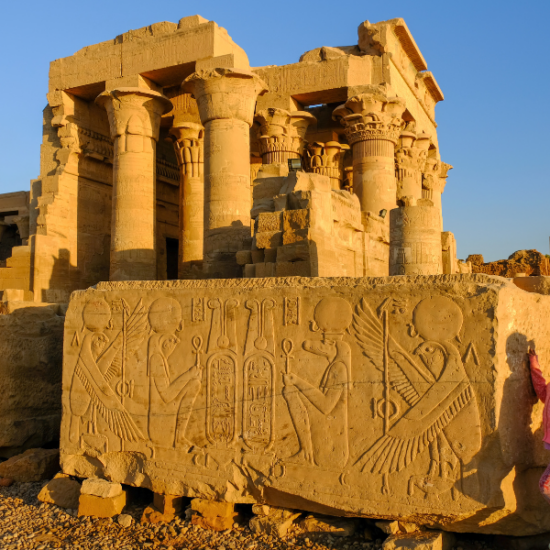A child standing beside Kom Ombo Temple in Egypt