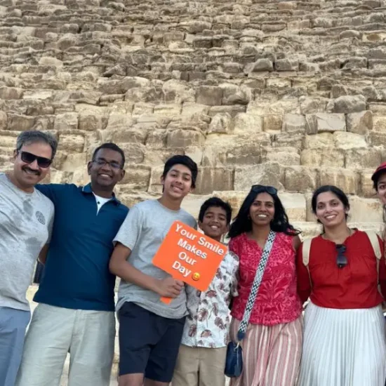 A family standing in front of the Pyramids of Giza in Egypt