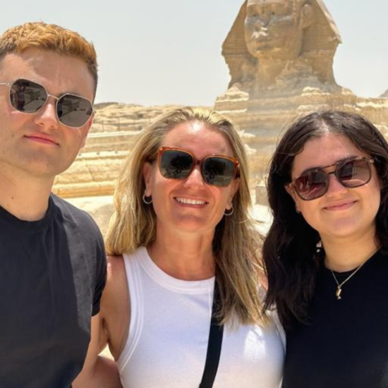A family standing in front of the Pyramids of Giza