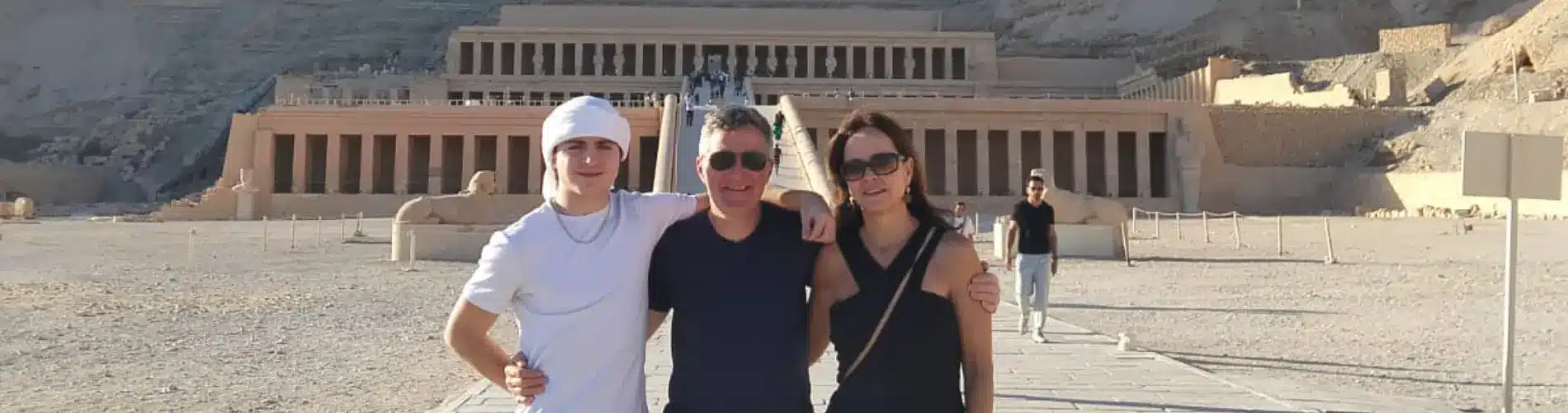A family standing in front of Hatshepsut Temple in Luxor as a part of our 7 Days Cairo, Nile Cruise and Alexandria Family Tour